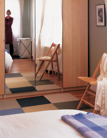 The large area rug in the master bedroom is made from carpet samples that Rick has collected over the years. The classic wooden folding chair was salvaged and refurbished.